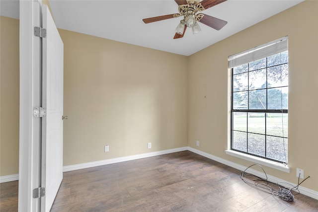 interior space with dark wood finished floors, a ceiling fan, and baseboards