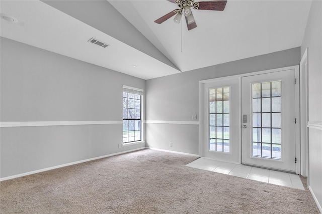 spare room featuring carpet, french doors, visible vents, a ceiling fan, and vaulted ceiling