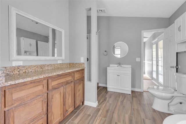 bathroom with visible vents, toilet, wood tiled floor, vanity, and baseboards