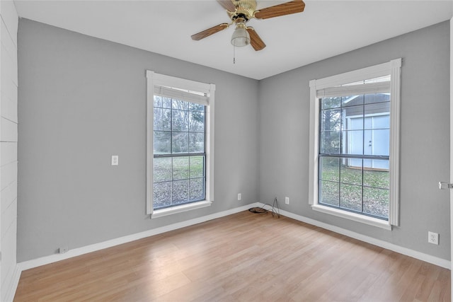 empty room featuring ceiling fan, baseboards, and wood finished floors