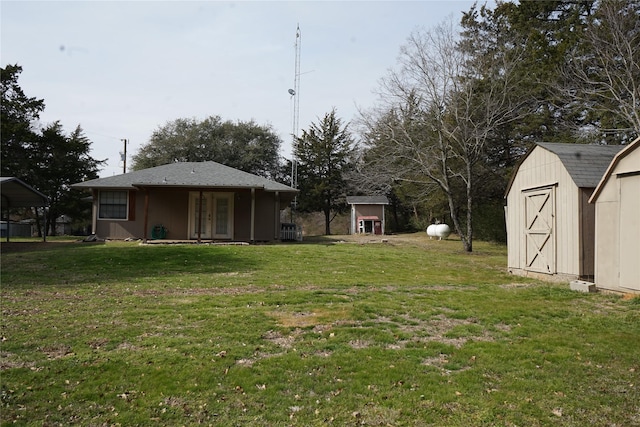 view of yard with a shed, an outdoor structure, and french doors