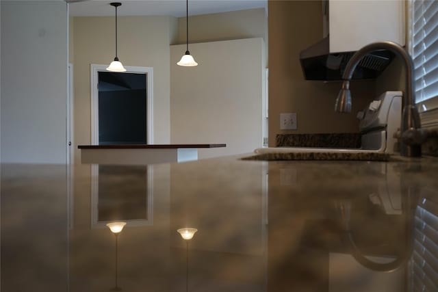 kitchen featuring extractor fan, dark countertops, and pendant lighting