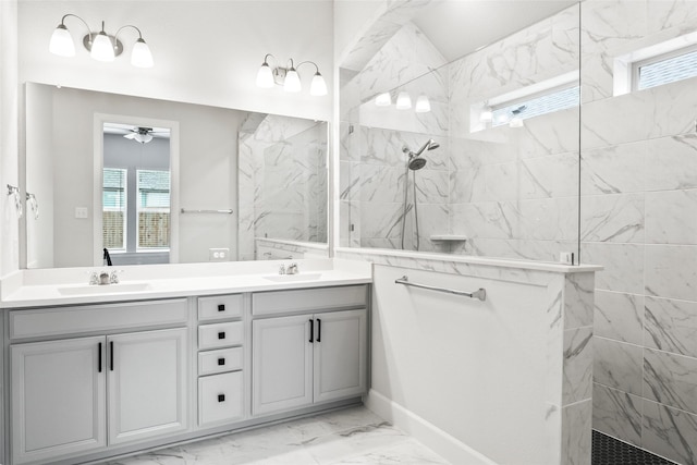 full bathroom with double vanity, marble finish floor, a walk in shower, and a sink