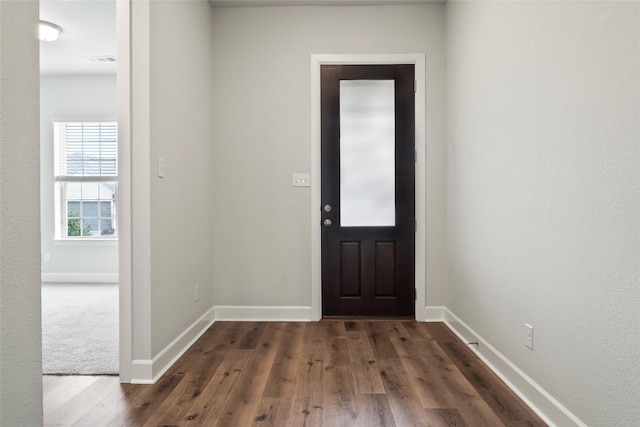 foyer entrance with dark wood-type flooring, visible vents, and baseboards