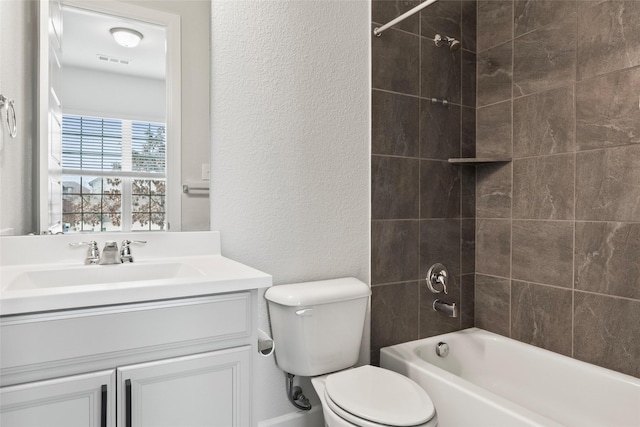 full bathroom with vanity, tiled shower / bath, and toilet