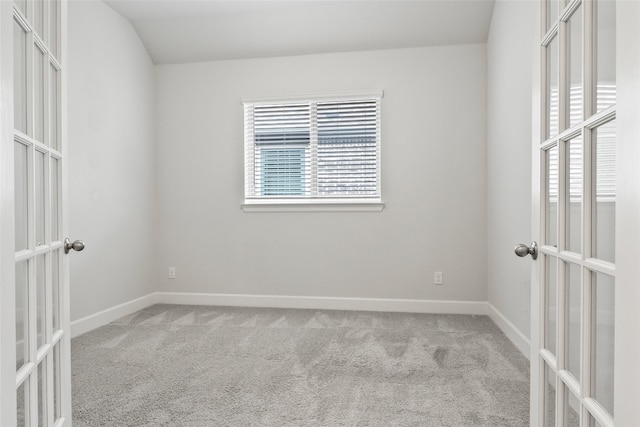 empty room with french doors, light carpet, and baseboards