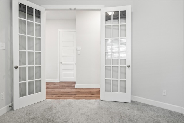 carpeted empty room with baseboards and french doors