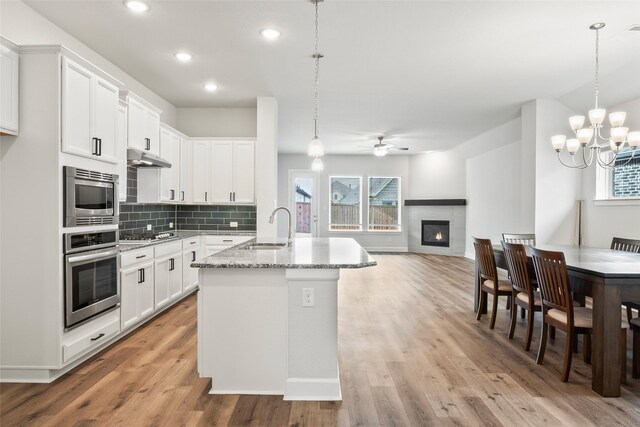 kitchen with stainless steel appliances, white cabinetry, and pendant lighting