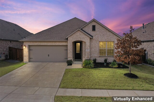 view of front of house featuring a garage and a lawn