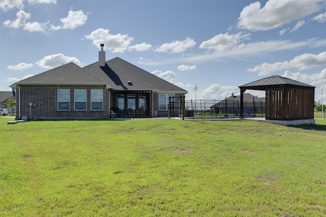 back of property with brick siding, fence, a yard, a gazebo, and a chimney