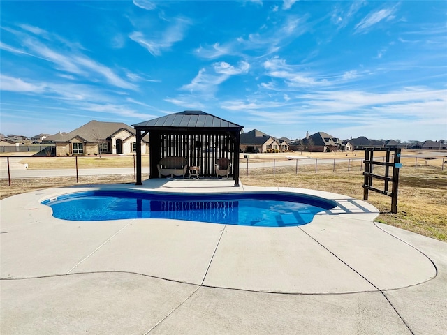 view of pool featuring a fenced in pool, a residential view, fence, a gazebo, and a patio area