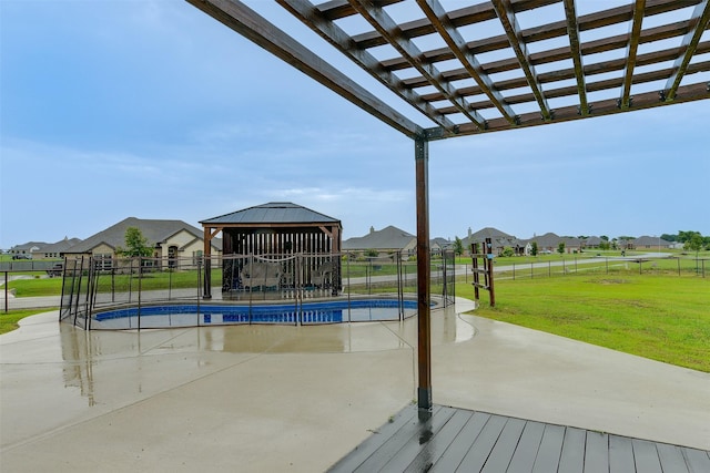 view of swimming pool featuring a gazebo, a yard, fence, and a residential view