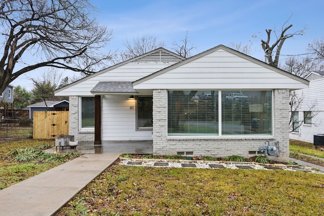 bungalow-style house with a front lawn and a patio