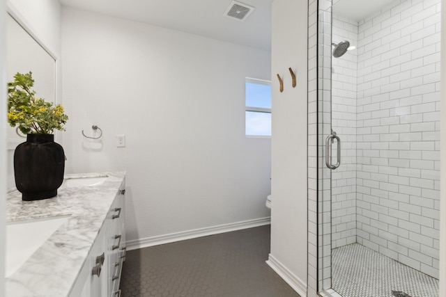 bathroom with tile patterned floors, vanity, toilet, and a shower with shower door