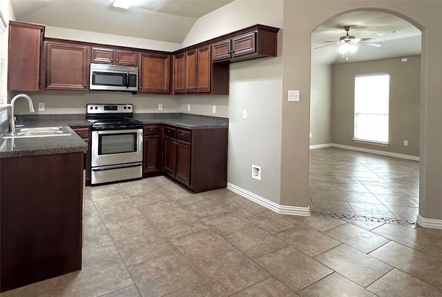 kitchen featuring appliances with stainless steel finishes, sink, lofted ceiling, and ceiling fan