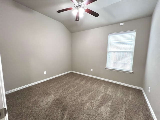 unfurnished room with ceiling fan, vaulted ceiling, and dark colored carpet