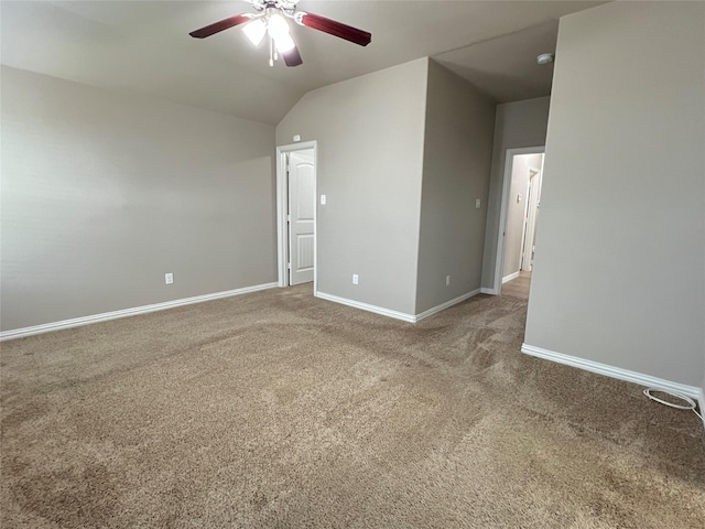 empty room with vaulted ceiling, ceiling fan, and carpet floors