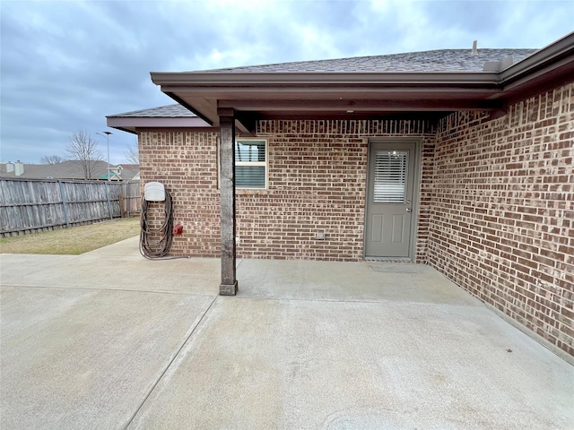 view of exterior entry with a patio area