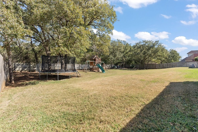 view of yard featuring a trampoline and a playground