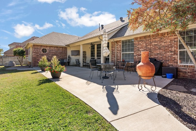 back of house featuring a lawn and a patio