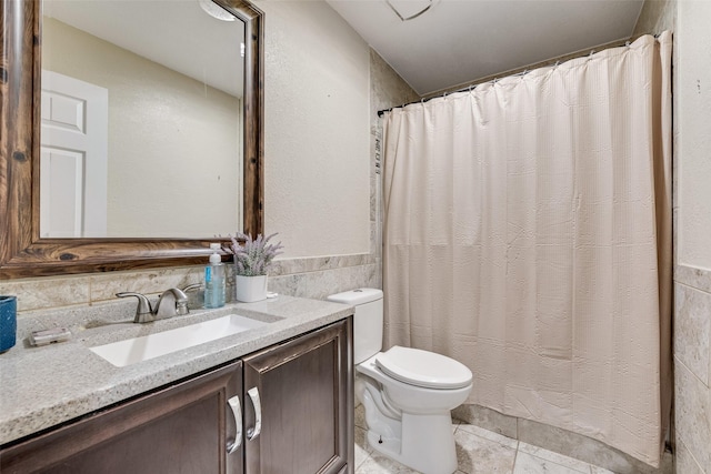 bathroom featuring vanity, tile walls, tile patterned floors, and toilet