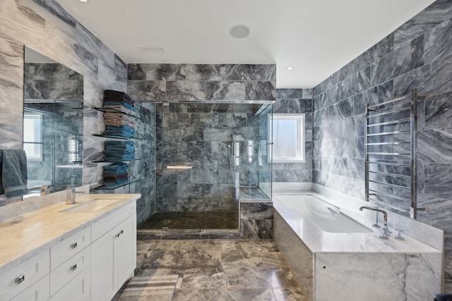 bathroom with vanity, independent shower and bath, and tile walls