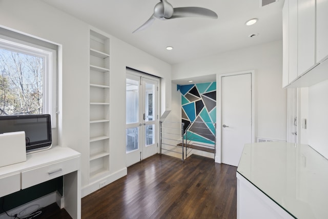 office space featuring built in features, dark hardwood / wood-style floors, ceiling fan, and french doors