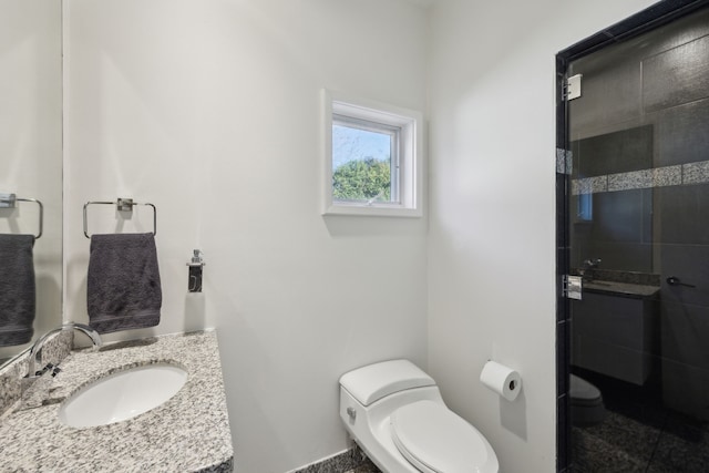 bathroom featuring sink, an enclosed shower, and toilet