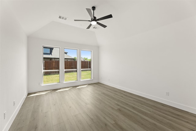 empty room with wood finished floors, baseboards, a ceiling fan, and visible vents