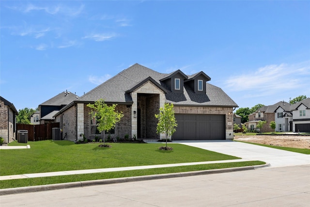 french country inspired facade featuring concrete driveway, an attached garage, fence, and roof with shingles