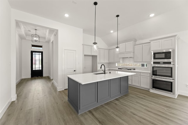 kitchen featuring a sink, light countertops, gas stovetop, light wood-style flooring, and built in microwave