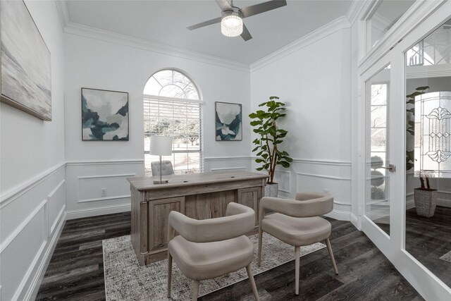 home office featuring dark wood finished floors, a decorative wall, ornamental molding, a ceiling fan, and a wainscoted wall