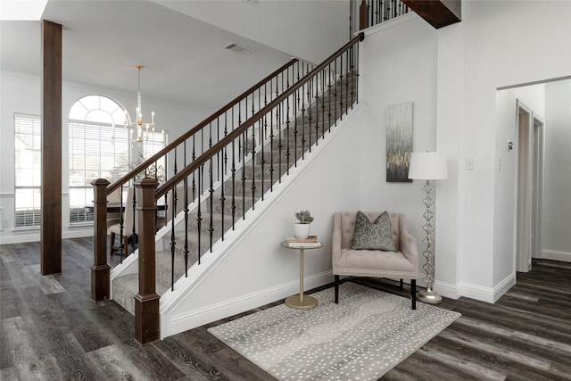 stairs featuring wood finished floors, baseboards, a chandelier, and crown molding