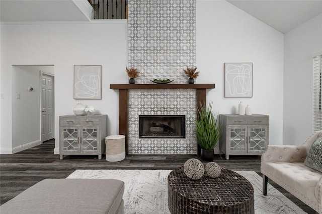 living room with dark hardwood / wood-style flooring, a fireplace, and high vaulted ceiling