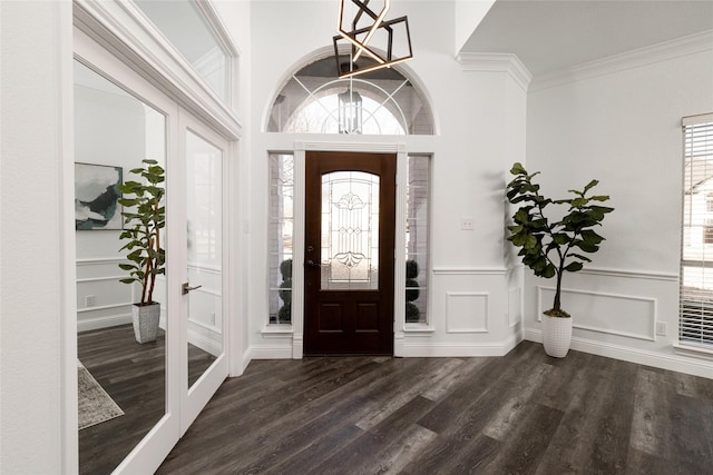 foyer featuring ornamental molding, an inviting chandelier, and dark hardwood / wood-style flooring