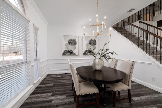 dining space with ornamental molding, dark wood-type flooring, and an inviting chandelier