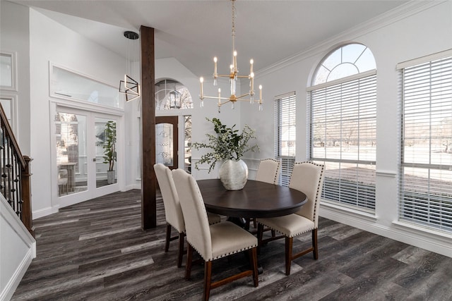 dining area with an inviting chandelier, dark wood-type flooring, ornamental molding, and french doors