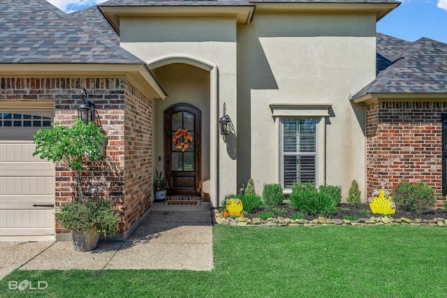 property entrance with a garage and a yard