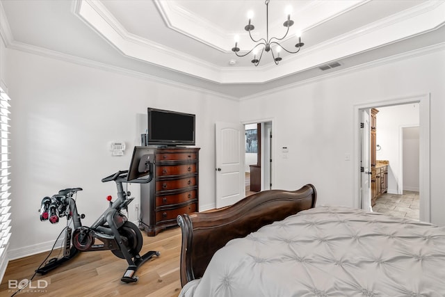 bedroom featuring a raised ceiling, crown molding, an inviting chandelier, and light hardwood / wood-style floors