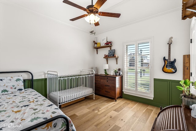 bedroom featuring ornamental molding, ceiling fan, and light hardwood / wood-style flooring