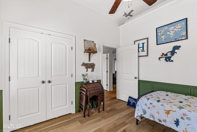 bedroom with crown molding, a closet, ceiling fan, and hardwood / wood-style flooring