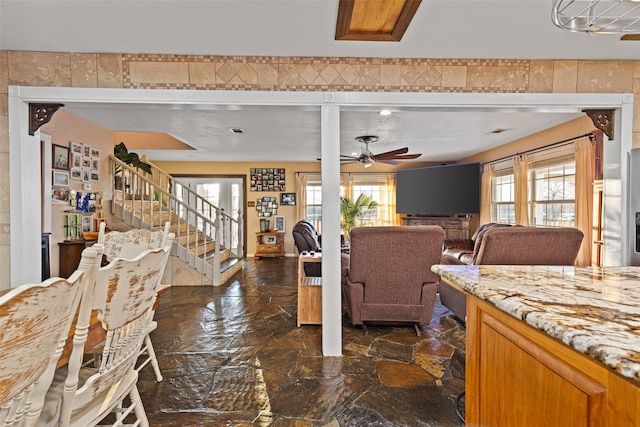 interior space with ceiling fan and a wealth of natural light