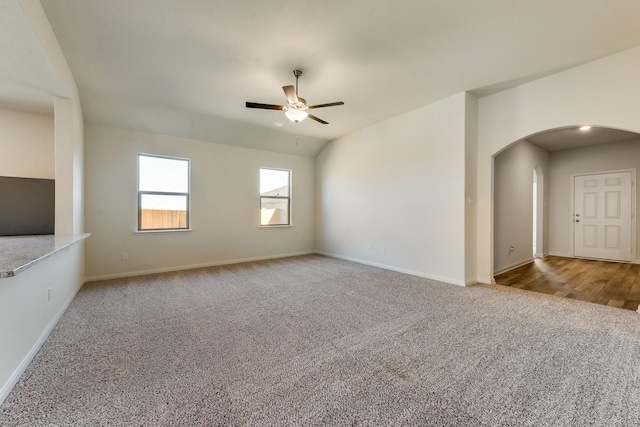 unfurnished living room with ceiling fan, vaulted ceiling, and light carpet