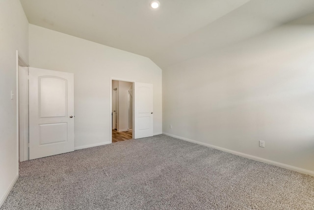 interior space with carpet flooring and vaulted ceiling