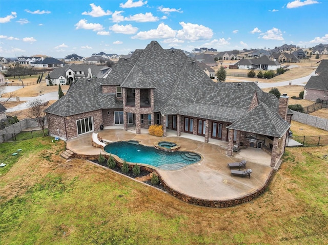 view of swimming pool with a fenced backyard, a residential view, an in ground hot tub, a yard, and a patio area