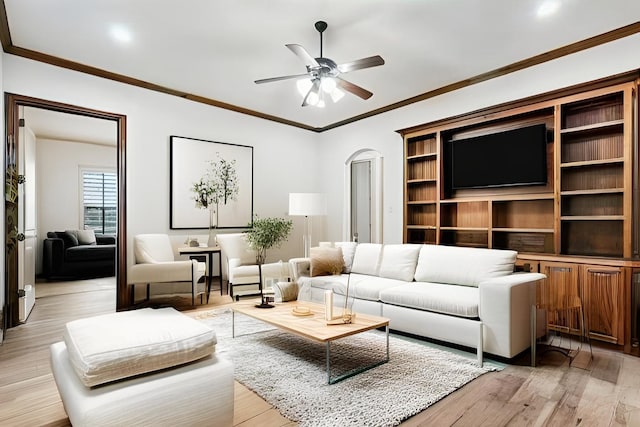 living area featuring light wood-style floors, ceiling fan, and ornamental molding