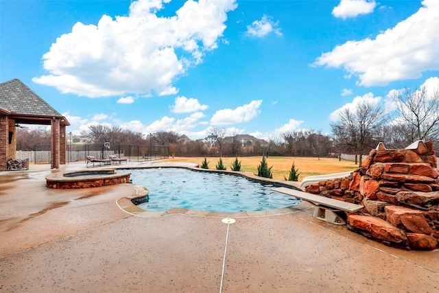 view of swimming pool featuring a patio area, a pool with connected hot tub, fence, and a water slide