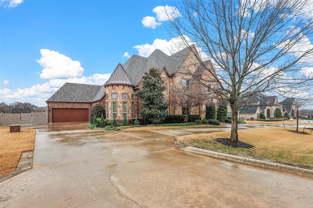 view of front of property featuring brick siding, concrete driveway, a standing seam roof, metal roof, and a garage