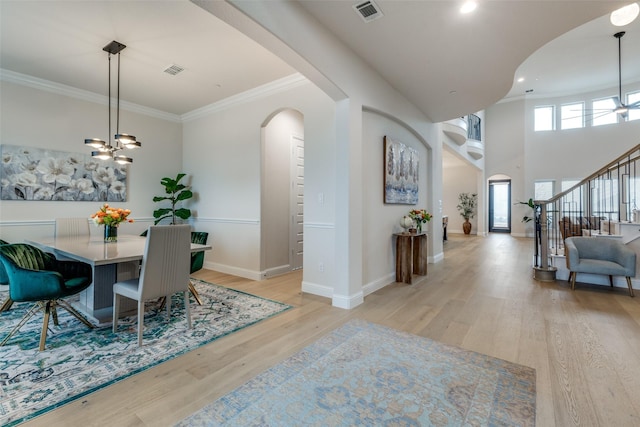 dining area featuring ornamental molding, a chandelier, and light wood-type flooring