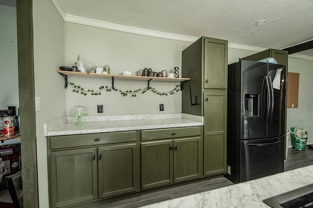 kitchen featuring hardwood / wood-style flooring, ornamental molding, and black fridge